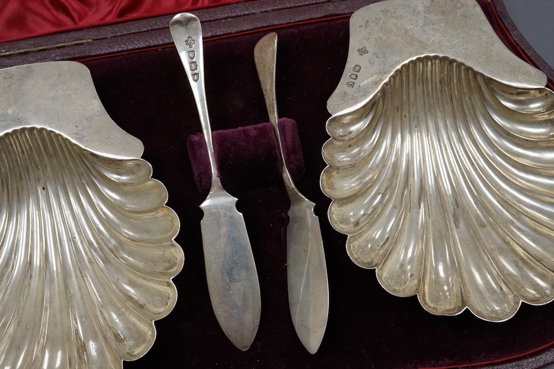 A late Victorian cased pair of silver butter shells and matching butter knives, by Horace Woodward & Co Ltd, London, 1894/5, shell 12.9cm, 5.6oz.